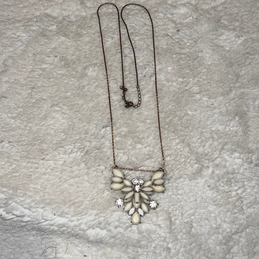 Long gold necklace with off white eblem